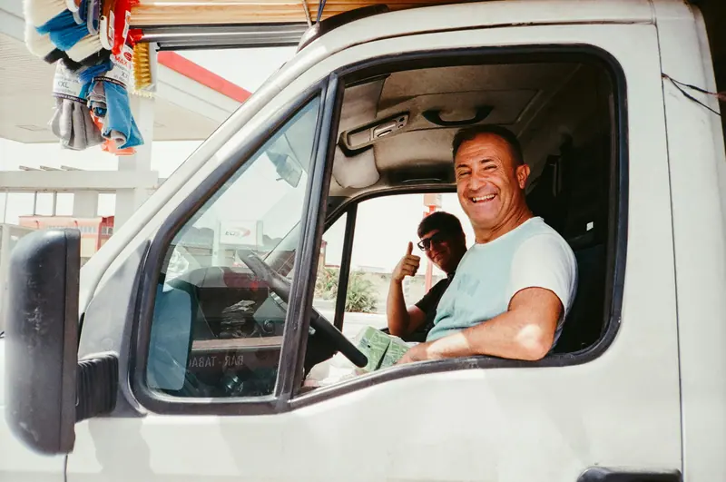 Smiling contractor leaning out of his work van window