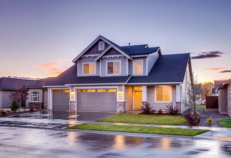 Craftsman-style house with a wet driveway at sunset