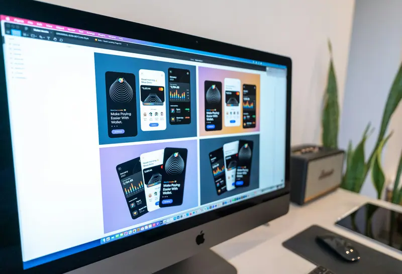 Website and app design layouts on a large desktop monitor